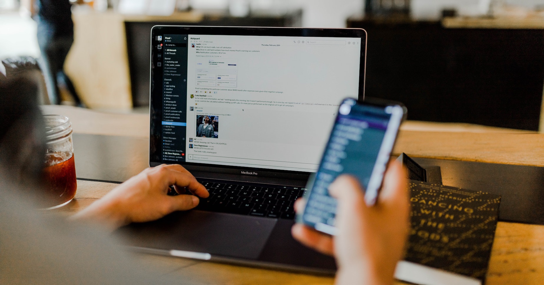 A person uses a project management tool on their phone and laptop