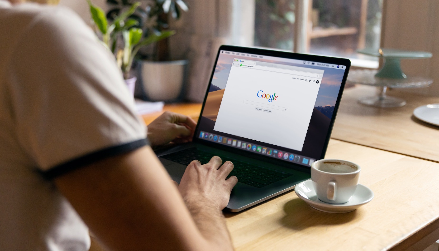 A person types a phrase into Google on their laptop